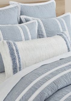 a bed with blue and white striped comforters