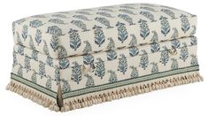 a blue and white ottoman sitting on top of a floor next to a pillow case