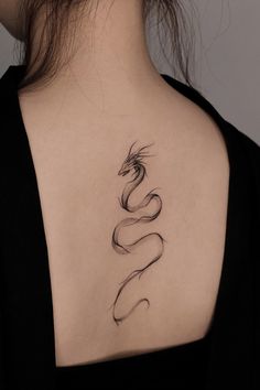 the back of a woman's neck with a snake tattoo on it