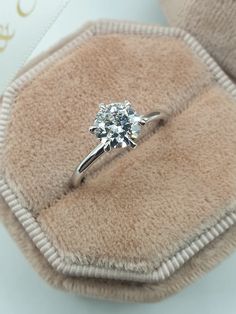 a diamond ring sitting on top of a cushion