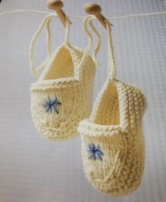 two crocheted baby shoes hanging from a clothesline with blue stars on them