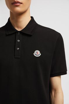 A timeless design that transcends seasons, this polo shirt is crafted from cotton pique. The classic style is embellished with a Moncler logo patch on the chest. Designer Short Sleeve Polo Shirt With Embroidered Logo, Cotton Polo Shirt With Logo Patch, Classic Black Top With Logo Patch, Casual Polo Shirt With Logo Patch, Collared Cotton Polo Shirt With Logo, Cotton Collared Polo Shirt With Logo, Collared Cotton Top With Logo Detail, Designer Cotton Tops With Ribbed Collar, Casual Cotton Polo Shirt With Logo Detail