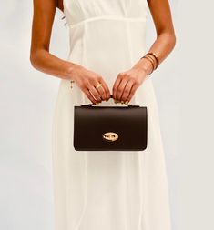 The Amelia Bag is set to be your favourite plus one. The perfect size for carrying all your essentials, making it your go-to bag for those special events. Made in Italy from smooth ruga leather, the bag is fully lined and features iconic gold detailing with a twist lock clasp and an internal zip pocket.   Carry yours by the top handle or attach the crossbody chain to go hands-free.  The stylish bag is delivered in a branded dust bag and includes a detachable gold crossbody chain strap. Wipe clea Elegant Shoulder Flap Bag For On-the-go, Elegant Flap Bag With Detachable Strap For On-the-go, Classic Top Handle Box Bag For On-the-go, Timeless Box Bag With Detachable Strap, Timeless Box Bag With Detachable Strap For Daily Use, Timeless Flap Bag With Detachable Handle For Daily Use, Luxury Top Handle Box Bag For On-the-go, Luxury Box Bag With Top Handle For On-the-go, Black Flap Bag With Detachable Handle For On-the-go