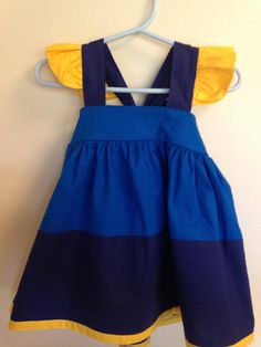 a blue and yellow dress hanging on a wall