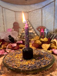 a lit candle sitting on top of a glass plate