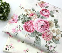 two pieces of fabric with pink flowers on them next to a potted plant in the background