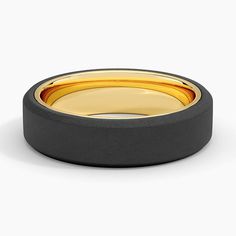 a black and gold wedding ring on a white background