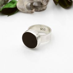 "This is an elegant round black onyx ring that catches the eye. It is very comfortable and perfect to wear at any time of the day. Its simple and refined design makes this ring a must-have piece of jewelry to combine with any outfit. This wide band ring is handmade in high-quality 950 solid silver. Shiny finish. 🌷 Nickel-free. Made from ethical and recycled silver. 👉 Look at the size conversion chart in one of the pictures. This ring is made TO MEASURE and on-demand. Make sure you choose the r Minimalist Onyx Signet Ring, Black Polished Round Band Rings, Minimalist Black Sterling Silver Ring, Modern Black Round Rings, Minimalist Black Round Band Ring, Polished Onyx Rings With Round Shape, Silver Onyx Round Ring, Minimalist Ring With Black Enamel, Black Enamel Onyx Round Rings