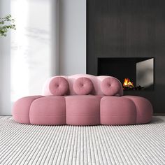 a pink couch sitting on top of a white floor next to a fire place in a living room