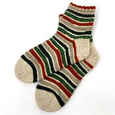 Ankle length hand knit socks with stretchy ribbed cuff.  SIZE: These socks are women's size 8-9. They measure (un-stretched) - 6" from top of cuff to floor at heel and 9" heel to toe.  COLOR: Beautiful stripes of muted tan, red and green with cream heels and toes. Perfect for Christmas!  The stripes have slight defects in the variation of the white stripes, but it is barely noticeable and they are still gorgeous!! MATERIALS: Made with a soft yarn of 75% Superwash Wool and 25% Nylon. Hand dyed by Casual Comfortable Hand Knitted Socks, Casual Green Knitted Socks, Warm Casual Christmas Socks, Casual Knitted Socks, One Size, Handmade Casual Socks For Fall, Casual Knitted Socks One Size, Casual Hand Knitted Socks, Casual Handmade Green Socks, Warm Red Casual Socks