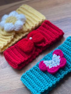 three crocheted headbands are laying on the floor next to each other