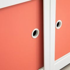 an orange and white cabinet with two holes in the side wall next to each other