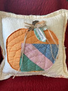 a decorative pillow with a patchwork pumpkin on it