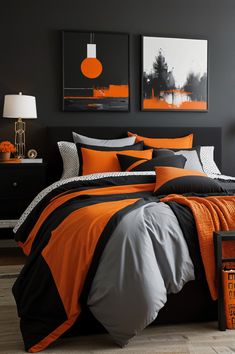 an orange and black bed in a bedroom with two pictures on the wall above it