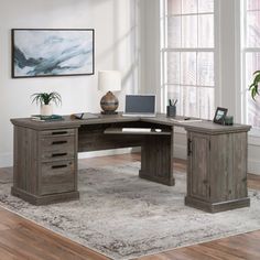 an office desk with a laptop on it and a chair in front of the desk