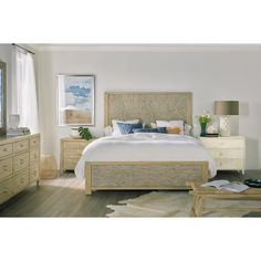 a bedroom with white walls and wooden furniture