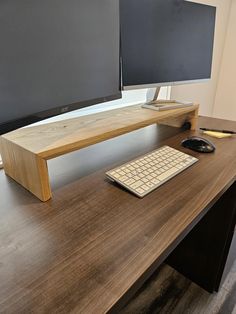 two computer monitors sitting on top of a wooden desk next to a keyboard and mouse