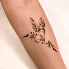 a black and white flower tattoo on the right arm, with an arrow in the middle