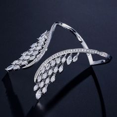 ◉ The Angel Wings Bracelet adds a unique and elegant touch to any outfit, making it perfect for any special occasion or daily wear. ◉ Made with high-quality 18K white gold plating and cubic zirconia embellishments, this bangle bracelet is a durable and long-lasting piece of jewelry. ◉ The angel wing design is a symbol of inspiration, guidance, and protection, making it a meaningful and thoughtful gift for yourself or a loved one. ◉ The luxurious design and high-quality materials make this bracelet a standout piece in any jewelry collection Angel Wings Bracelet, Stylish Jewelry Accessories, Wing Ring, Angel Wing Bracelet, Gems Bracelet, Gold Armband, Bracelet Ring, Bangle Designs, Stylish Jewelry