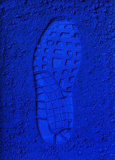 a blue shoe is on the ground with it's soles up and down