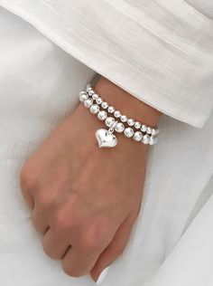 925 Sterling Silver Stretch XL Puff Heart Charm Bracelet 8mm Sterling Silver Beads 18mm Sterling Silver Puff Heart Charm Stack of 2 includes: one Heart Charm Bracelet one 6mm Plain Bracelet Stack of 3 includes: one Heart Charm Bracelet one 6mm Plain Bracelet one 8mm Plain Bracelet These  bracelets are perfect for stacking or just wear them on their own. Affordable White Heart-shaped Beaded Bracelets, Silver Heart Bracelet With Double Heart Beads, Silver Heart Bracelet With Heart Beads, Silver Double Heart Bracelet With Heart Beads, Silver Double Heart Bracelets With Heart Beads, Silver Heart Bracelet With Round Beads For Valentine's Day, Plain Bracelet, Stacked Bracelets, Puffed Heart