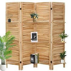 a room divider made out of wood with potted plants and books on it