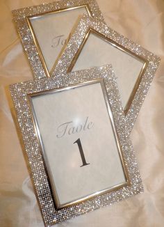 the table numbers are displayed in three square frames with silver sequins on them