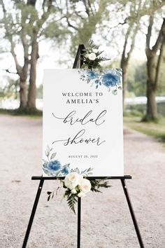 a welcome sign with flowers and greenery on it