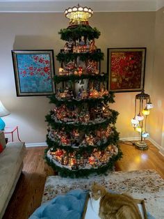 a cat is sitting on the floor in front of a christmas tree that has been decorated