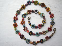 A short daisy chain necklace .. Japanese and Czech glass seed beads form small flowers, with larger seed beads between. Colours are muted earthy shades, with a bronze plated lobster claw clasp.  Flowers are approximately 9mm in diameter. 17.5" in length.   If you would like a little more room, please message me and I will add a 2" extension chain at no extra cost. Bohemian Multicolor Flower Necklace With Beaded Chain, Multicolor Bohemian Flower Necklace With Tiny Beads, Bohemian Flower Necklace With Tiny Beads, Bohemian Flower Shaped Beaded Chain, Flower Shaped Beaded Necklaces With Tiny Beads For Festivals, Flower Shaped Beaded Necklace With Tiny Beads For Festivals, Festival Flower Shaped Beaded Necklace With Tiny Beads, Multicolor Flower-shaped Beaded Necklaces, Multicolor Flower-shaped Beaded Necklaces With Tiny Beads