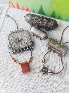 Bedouin silver-amult convulut of different sizes & shapes: Silver Hirz hallmarked with knobs.70 gr. heavy 12 cm long. 2. decorated with silver wire, 7 cm long, 25 gr. heavy.3. Rashaida Bedouin Hirz decorated with silver wire / plates, old Yemeni handicraft with bells as pendant.7 cm wide. 4. Elegant silver Hirz 27 gr. Heavy. 5. small leather amulet + small, very nicely cleaned amulet Yemeni Jewelry, Decorative Metal Sheets, Beach Jewelry Boho, Kuchi Jewelry, Talisman Jewelry, Ribbon Jewelry, Casting Jewelry, Handcrafted Artisan Jewelry, Ancient Jewelry