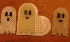 three pieces of plastic bead with faces and eyes in the shape of a heart