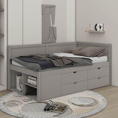 a bed sitting on top of a wooden floor next to a book shelf