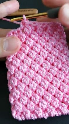 someone is crocheting the stitchs on their pink knitted dishclothes