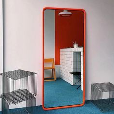 an orange mirror sitting on top of a blue floor