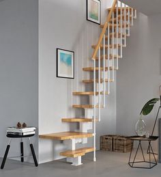 a white staircase with wooden steps in a living room next to a table and chair