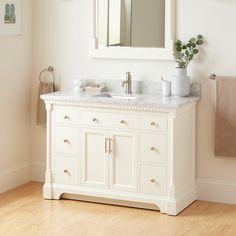 a white bathroom vanity with two sinks and a large mirror over it's top