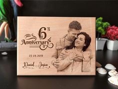 a wooden anniversary card with an image of a man and woman hugging each other on it