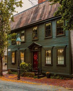 a green house with a red door and windows