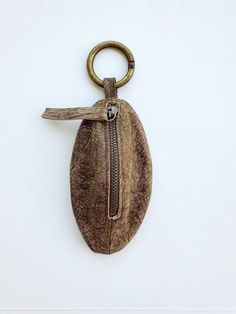 a keychain with a zipper hanging from it's side on a white wall