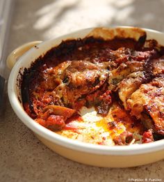 a casserole dish with meat and cheese in it sitting on a counter top