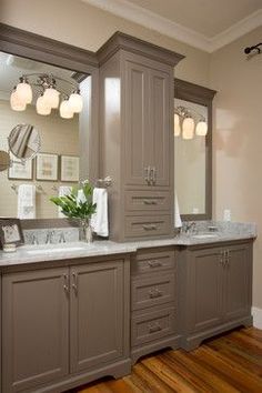 a bathroom with two sinks, mirrors and lights on the wall above them is shown