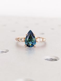 a blue and white diamond ring sitting on top of a table