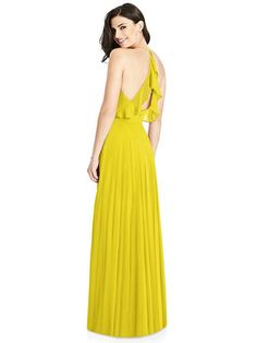 a woman in a long yellow dress is looking back at the camera and she has her hands on her hips