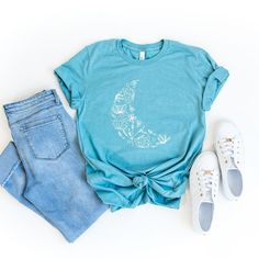 Looking for a cute versatile top to wear? Make sure to grab one of our Graphic tees! This soft and comfortable graphic tee is the perfect top for any outfit. It can be paiMaroon with biker shorts, jeans, or even a simple skirt/dress! This tee is true-to-size, so be sure to order your regular t-shirt size! If you are looking for a more oversized look, make sure to size up! Casual Short Sleeve T-shirt With Moon Print, Comfortable Blue T-shirt With Graphic Print, Casual Moon Print Short Sleeve T-shirt, Relaxed Fit Moon Print Short Sleeve Tops, Blue Graphic Print T-shirt For Loungewear, Blue Soft-washed T-shirt For Loungewear, Soft-washed Blue T-shirt For Loungewear, Trendy Cotton T-shirt With Moon Print, Casual Cotton T-shirt With Moon Print