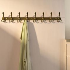 a coat rack with umbrellas hanging from it's hooks on the wall next to a dresser