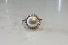 Cleopatra, Princess Di, Jackie O - all loved pearls. The classic gem for classic beauties. This stunning ring features a freshwater pearl encircled by lustrous crystals. Available in silver or gold. Adjustable, size 5-8 PRODUCT DETAILS: 10mm AAA freshwater button iridescent pearl Luster - High Setting: sterling silver or 14kt gold plated with crystal mount Size: Adjustable, Size 5-8 Materials: Freshwater Pearl and .925 sterling silver coated in rhodium or 14kt gold plated over .925 sterling silver Wedding Pearl Rings With Pearl Pendant, Elegant Wedding Rings With Pearl Pendant, Elegant Pearl Pendant Ring As Gift, Fine Jewelry Pearl With Prong Setting, Timeless Akoya Pearl Ring, Fine Pearl Jewelry With Prong Setting, Pearl Jewelry With Prong Setting, Timeless Pearl Drop Rings As Gift, Timeless Pearl Drop Rings For Gifts