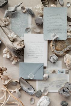 an assortment of seashells and other items are arranged on a table with paper