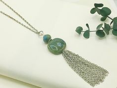 "Chain Tassel Necklace, Long Pendant Necklace, Long Necklaces for Women, Boho Tassel Necklace, Boho Necklace for Women, Long Silver Necklace This gorgeous tassel necklace brings boho vibes. This beauty has a generous 3 inch tassel made from pieces of antique silver textured cable chain; it's topped with two beautiful bluish, green ceramic focal beads, along with a silver floral bead cap & an antique silver textured decorative ring. A matching antique silver textured cable chain & a lobster clasp closure completes the necklace. Length of Necklace: 29 inches ---  Chain: Antique Silver Plated Stainless Steel -------  A 2 inch extender chain is included----  Pendant: 1.25 L X 1\" W Ceramic Bead & .25\" Ceramic Topper Bead --------   Closure: Lobster Clasp  Please note: Due to the one of a kind Tassel Long Necklace Jewelry For Gifts, Long Tassel Necklace As Gift, Long Tassel Necklace Jewelry For Gift, Long Tassel Necklace For Gifts, Tassel Necklace With Round Beads For Gifts, Green Tasseled Jewelry For Gifts, Pendant Necklace Long, Tassel Necklace Boho, Long Silver Necklace