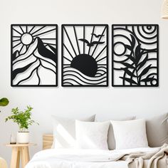 a bed sitting under two black and white paintings